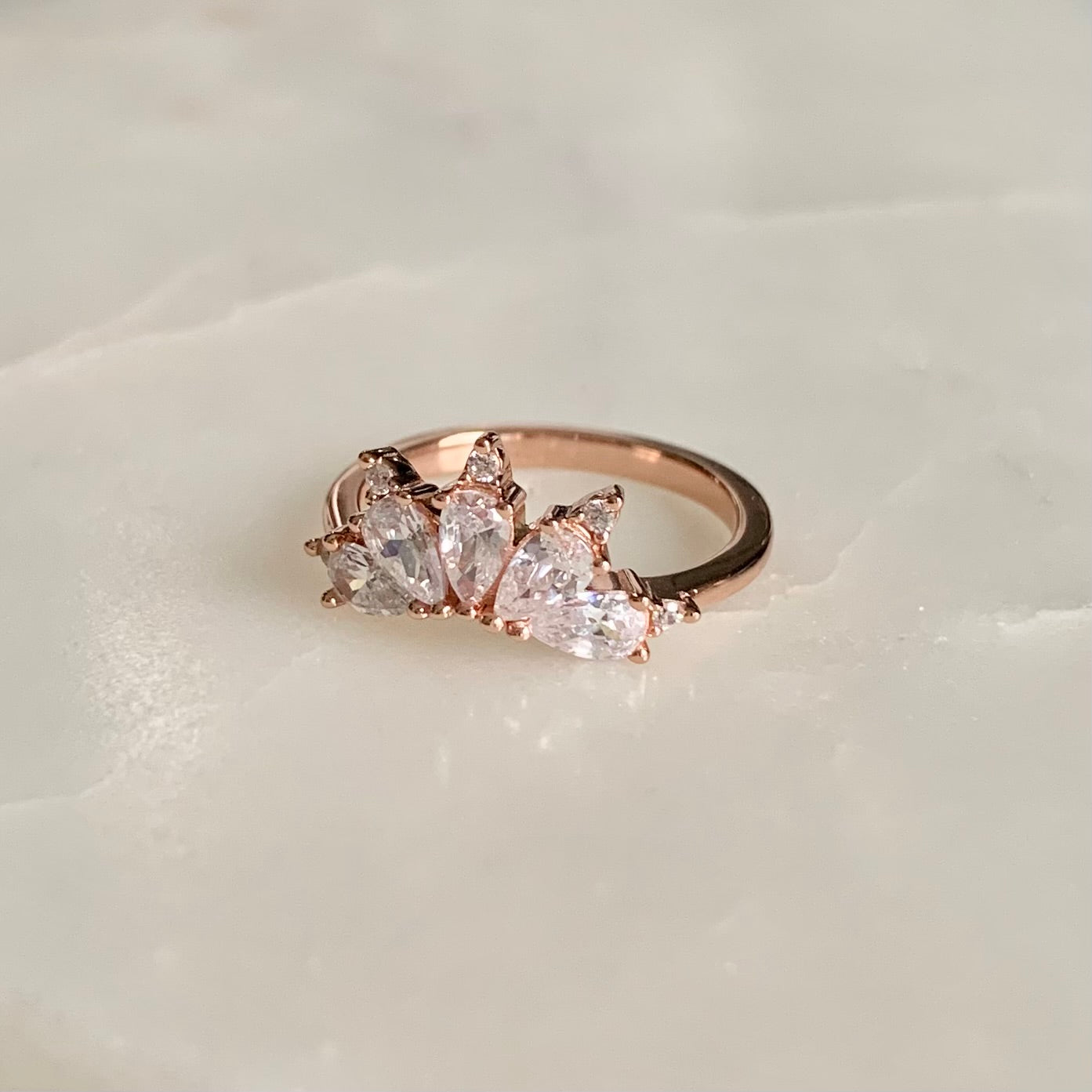 The Magic Ring is an ultimate crown ring in 18K rose gold Vermeil. It is embellished with five sparkling cubic zirconia crystals on a glistening band. The ring gives you an elegant look and is perfect for everyday wear.