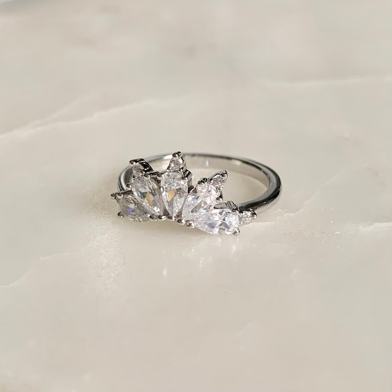 This Magic Ring is an ultimate crown ring in Rhodium Vermeil. It is embellished with five sparkling cubic zirconia crystals on a glistening band. The ring gives you an elegant look and is perfect for everyday wear.