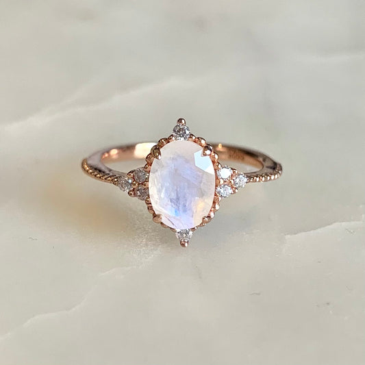 14K rose gold vermeil Queenie Moonstone Ring.  It has an oval moonstone set in a classic four-prong setting, embellished with tiny round beads and sparkling cubic zirconia crystals which highlights the femininity of its design. It is a truly meaningful piece of wearable art.