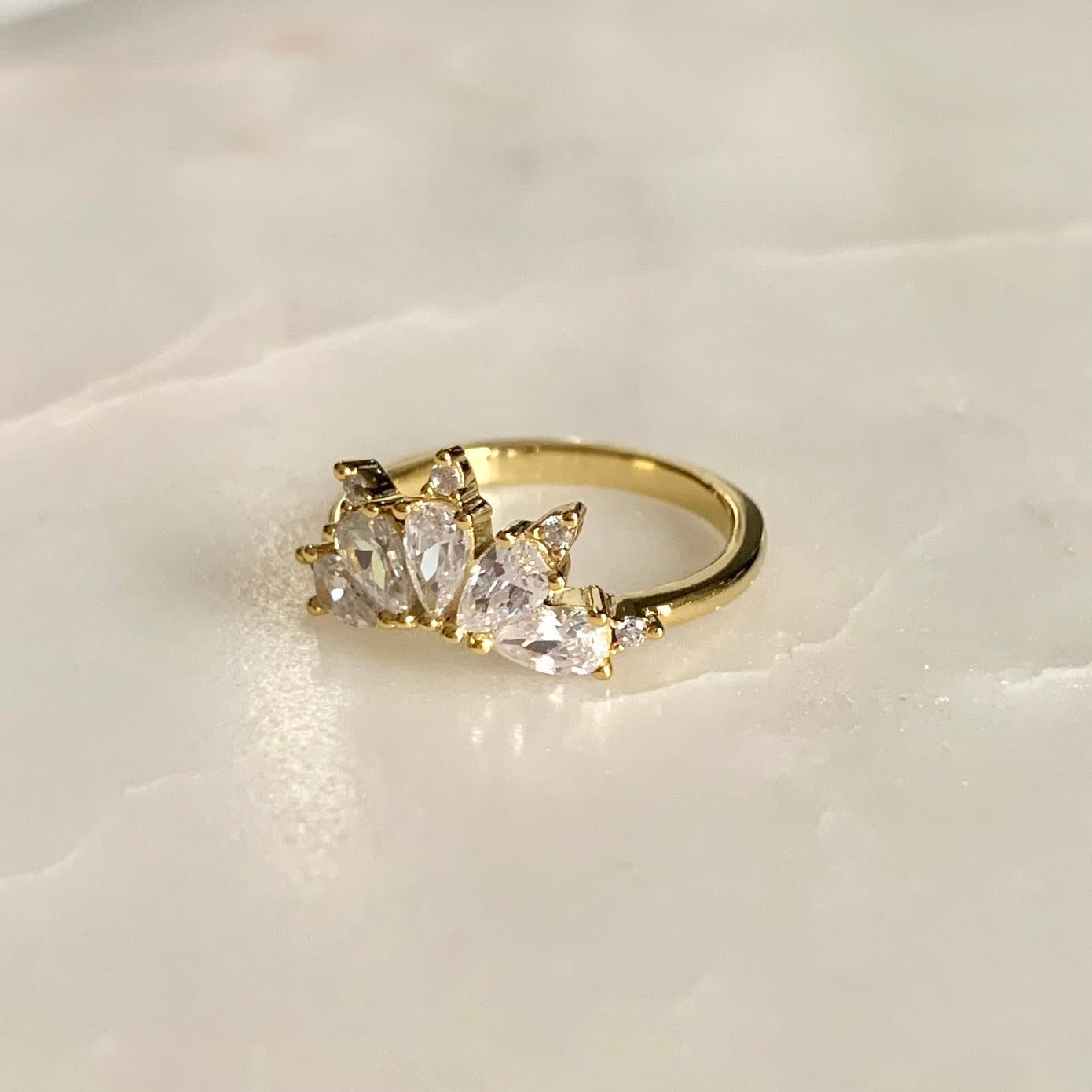 The Magic Ring is an ultimate crown ring in 14K yellow gold Vermeil. It is embellished with five sparkling cubic zirconia crystals on a glistening band. The ring gives you an elegant look and is perfect for everyday wear.