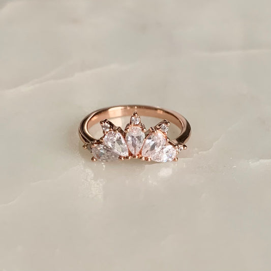 The Magic Ring is an ultimate crown ring in 18K rose gold Vermeil. It is embellished with five sparkling cubic zirconia crystals on a glistening band. The ring gives you an elegant look and is perfect for everyday wear.