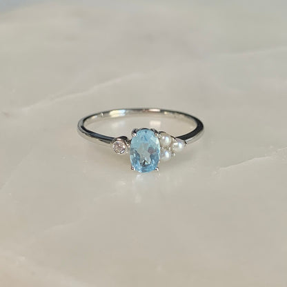 The Azora Sky Blue Topaz Ring has a natural sky blue topaz set in the centre, embellished with three freshwater pearls and a cubic zirconia crystal on the sides.  Blue topaz symbolises honesty, clarity of feelings, and deep emotional attachment. This is perfect as a friendship ring.