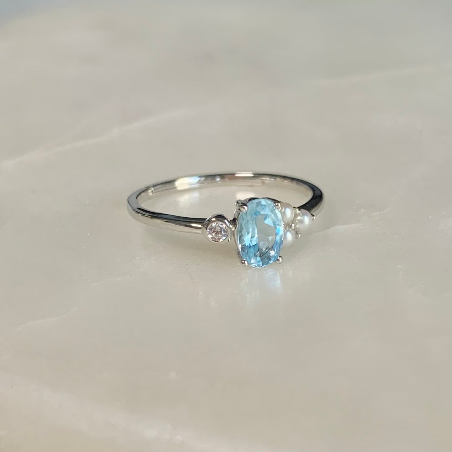 The Azora Sky Blue Topaz Ring has a natural sky blue topaz set in the centre, embellished with three freshwater pearls and a cubic zirconia crystal on the sides.  Blue topaz symbolises honesty, clarity of feelings, and deep emotional attachment. This is perfect as a friendship ring.