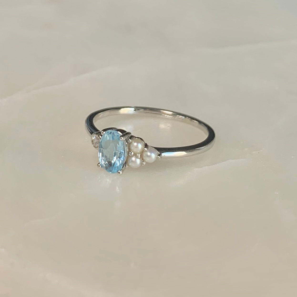 The Azora Sky Blue Topaz Ring has a natural sky blue topaz set in the centre, embellished with three freshwater pearls and a cubic zirconia crystal on the sides.  Blue topaz symbolises honesty, clarity of feelings, and deep emotional attachment. This is perfect as a friendship ring.