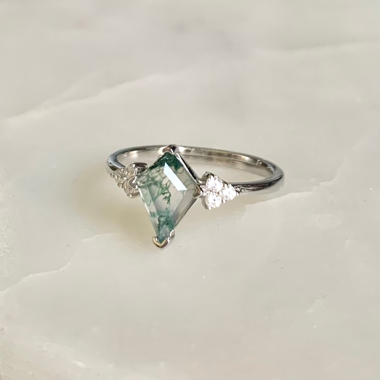 The Evelyn Ring features a unique kite-shaped Moss Agate that is sitting in the centre on a glistening rhodium plated band, accompanied by the sparkled cubic zirconia crystals on both sides. Evelyn is absolutely a unique ring for that one-of-a-kind someone.