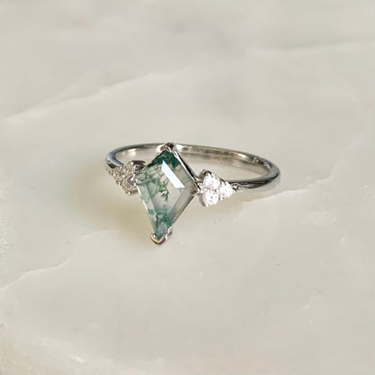 The Evelyn Ring features a unique kite-shaped Moss Agate that is sitting in the centre on a glistening rhodium plated band, accompanied by the sparkled cubic zirconia crystals on both sides. Evelyn is absolutely a unique ring for that one-of-a-kind someone.