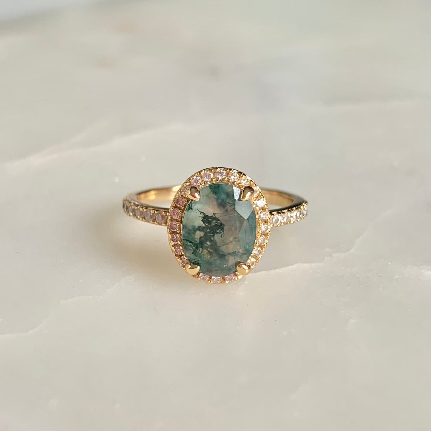 Crafted with exquisite detail, this Fern Moss Agate Ring is perfect for creating an air of sophistication. The halo-style design is adorned with shimmering cubic zirconia set in a feminine, floral pattern. Capture elegant style with this unique piece.