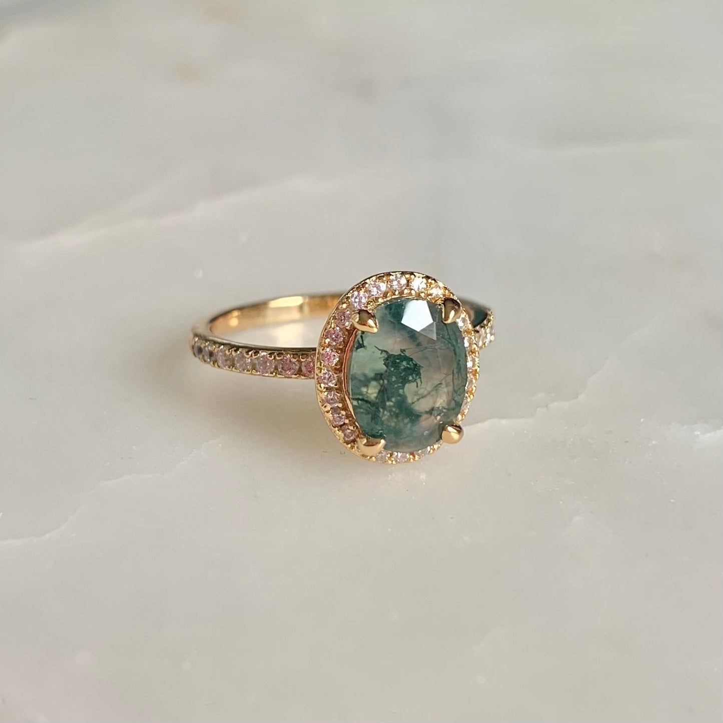 Crafted with exquisite detail, this Fern Moss Agate Ring is perfect for creating an air of sophistication. The halo-style design is adorned with shimmering cubic zirconia set in a feminine, floral pattern. Capture elegant style with this unique piece.